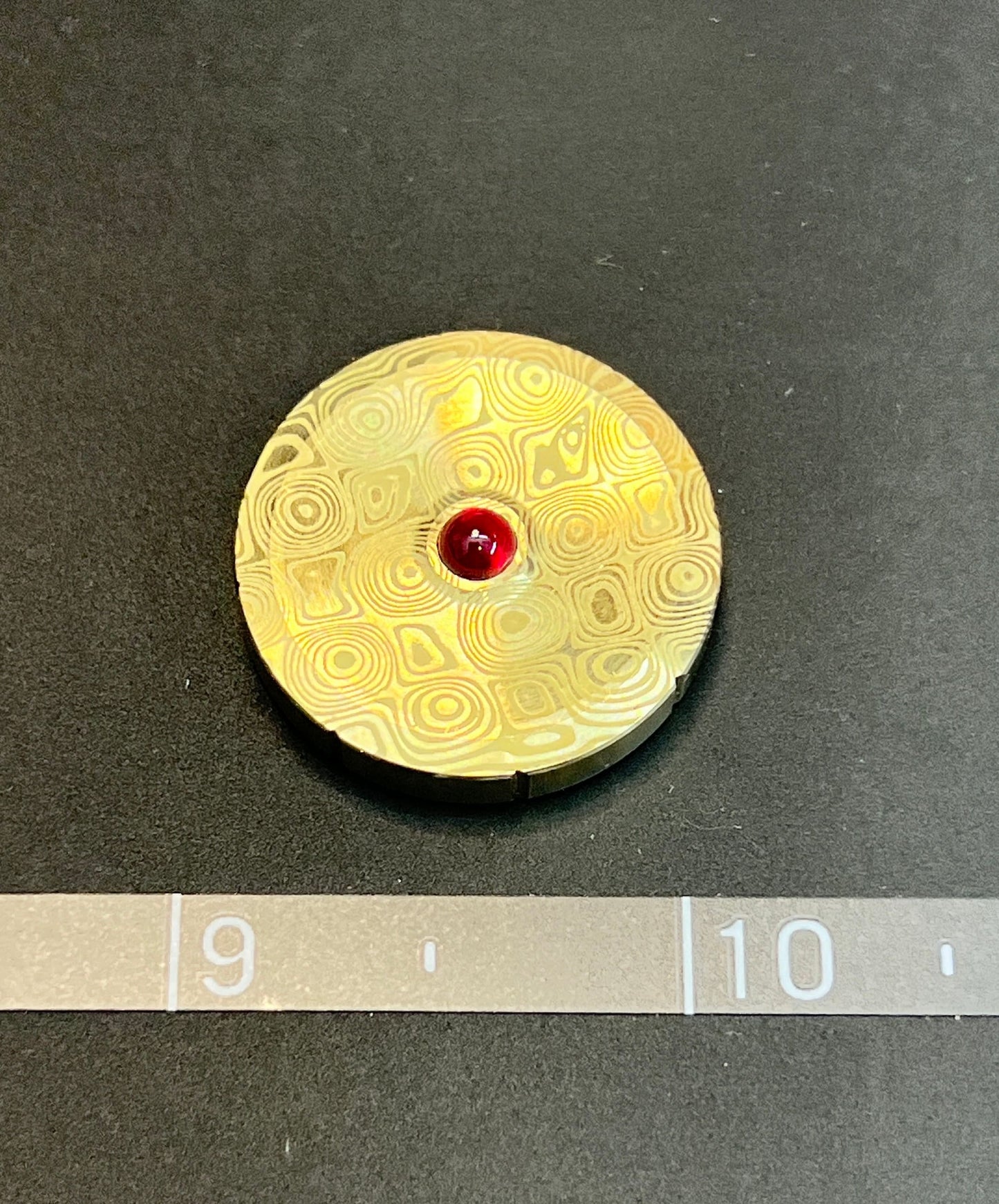 Brass Engraved Spinning Worry Coin with Ruby bearing.